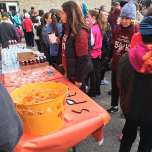 Runners in winter jackets crowding around the Today's Special table and its orange bucket of treats