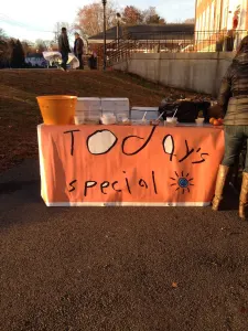 The Today's Special table with its hand-painted orange banner in the early morning sun