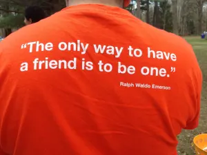 The back of an orange shirt printed with the quote: The only way to have a friend is to be one