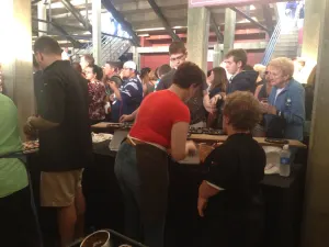 Guests lining up at the food stations under the stadium stands
