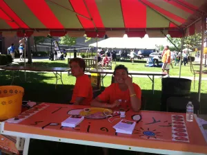 Team members at the Today's Special table under a red and white striped tent